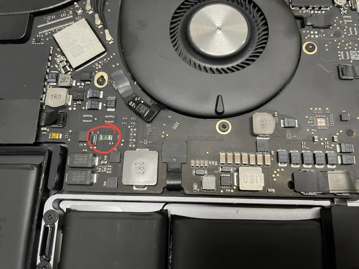 Thermal inspection of a MacBook Pro A2991 (M3) logic board on a bench power supply, with a red circle marking the inductor and adjacent MOSFET that overheated due to abnormal 2.7-amp current draw on a regulated power rail